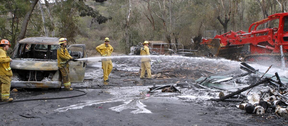 In this 2014 file photo, firefighters spray water on the remnants of a maintenance shed after it was destroyed by fire in La Cañada Flintridge. County sheriff and fire officials presented a report of their recent activities to the council Tuesday.