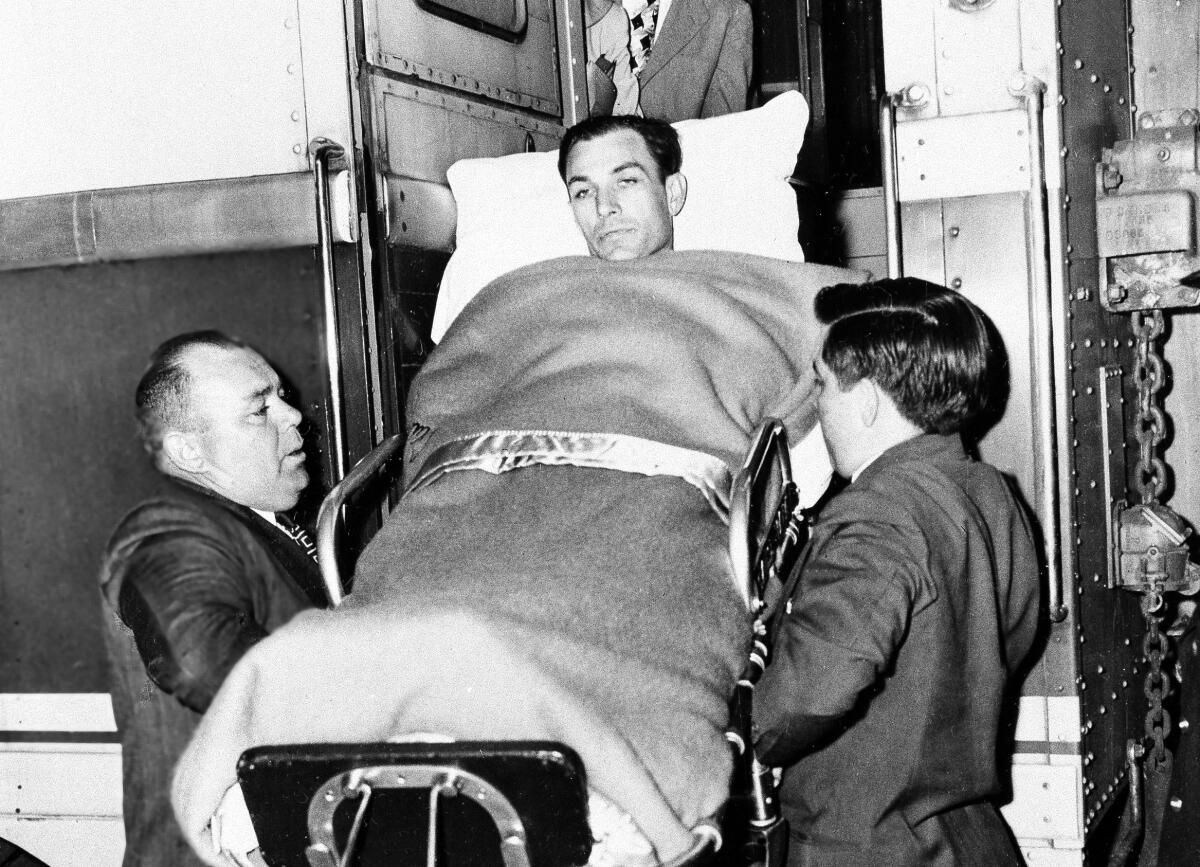 Golfer Ben Hogan is taken off a train in Fort Worth after being hospitalized following a car crash in 1949.