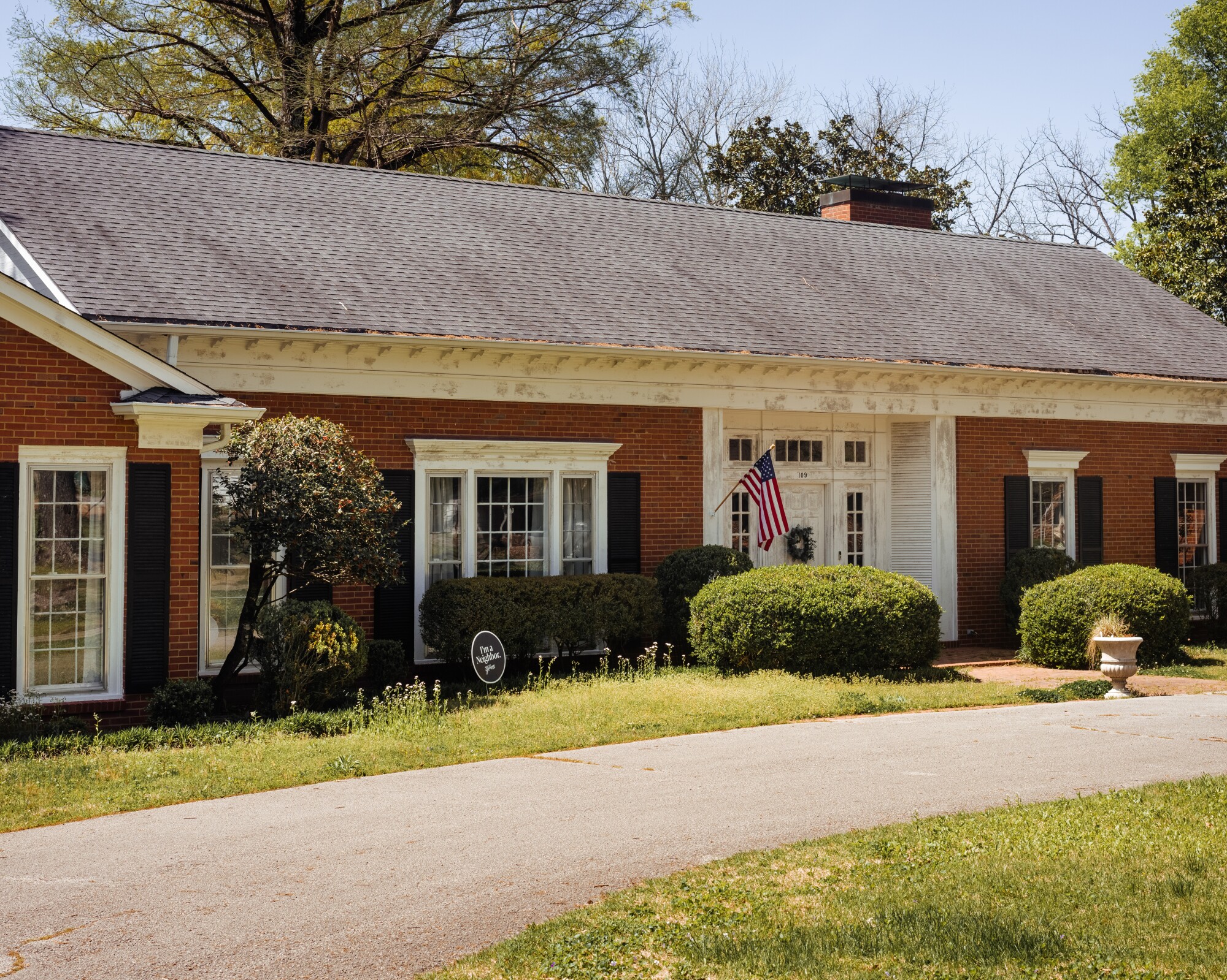 A brick house with an American flag flying.