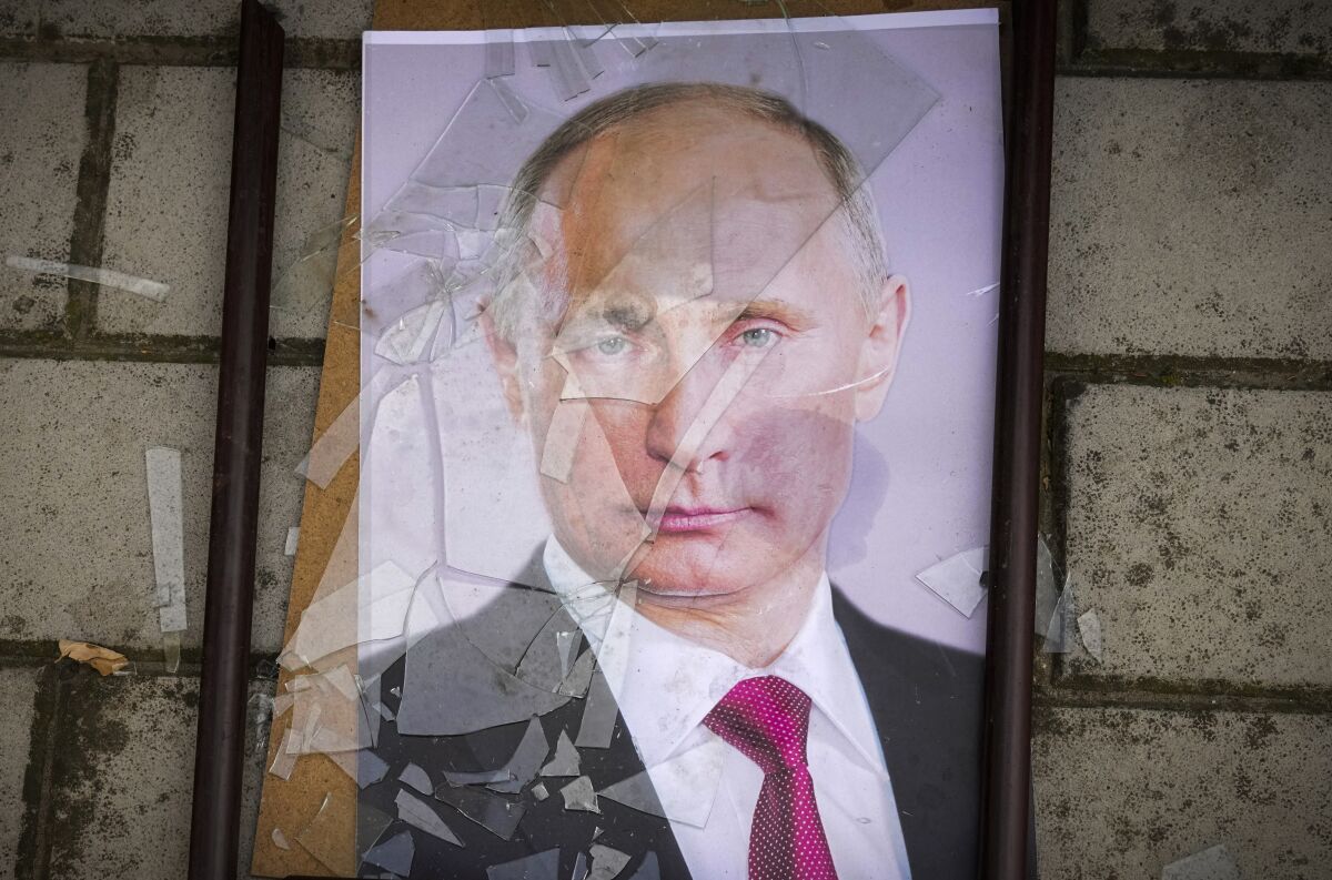 Archivo - Un retrato del presidente ruso Vladimir Putin yace en el suelo con su marco roto