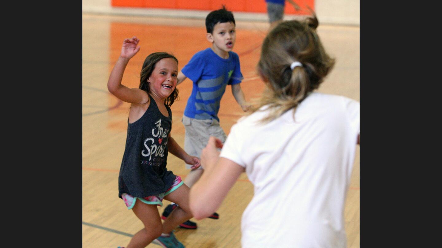 Sharks Lucianna Smith, 6, and Darren Cortez, 6, of Glendale, work to trap minnow Sloan Kittle, 9, of Glendale during a game of sharks and minnows at the YWCA of Glendale on Thursday, July 27, 2017. The 10-year-old program works in partnership with Glendale Arts, providing scholarships for 25 children in the Domestic Violence Program and low-income families.