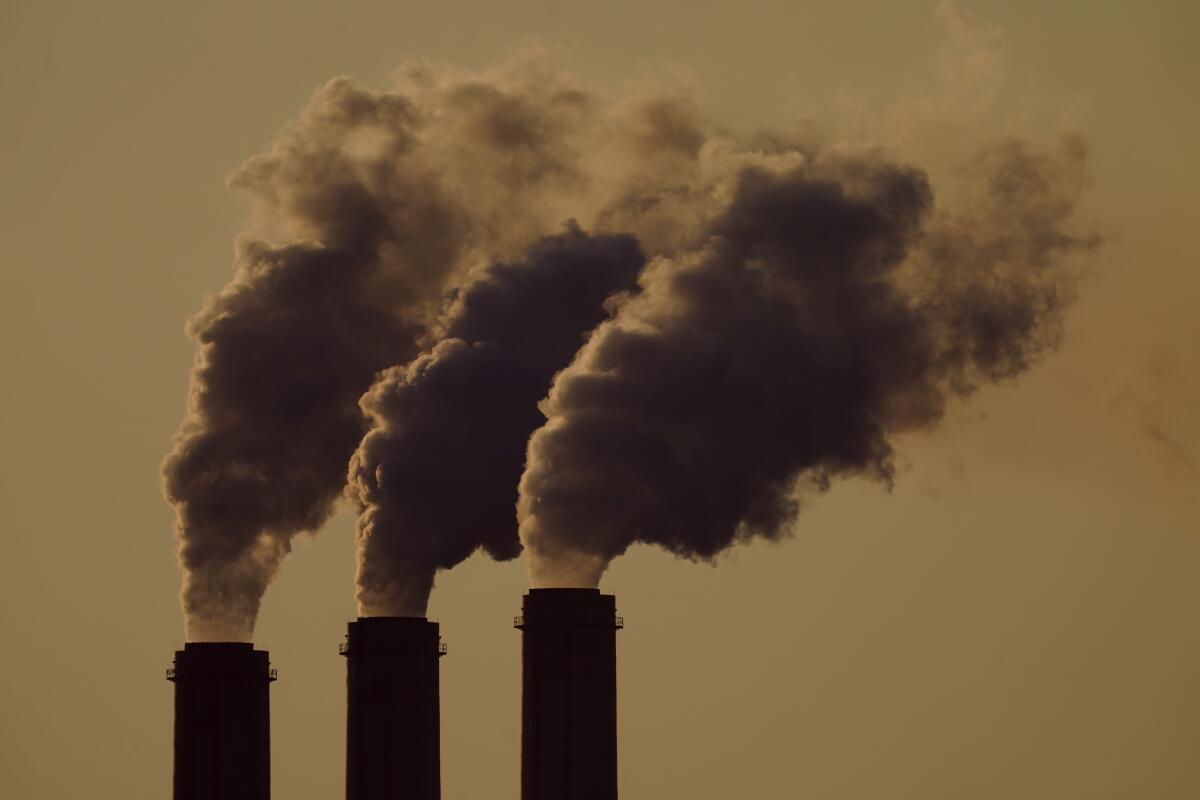 Emissions billowing from three smokestacks