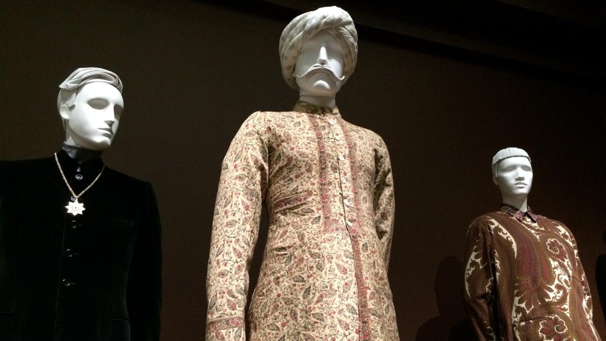 One part of the exhibition looks at the ways in which Eastern fashion has influenced the West. From left, a 1968 silk velvet Nehru suit by Gilbert Féruch, a late 19th century wool sherwani long coat from India and a paisley outfit from 2013-14 by Belgian designer Dries Van Noten.