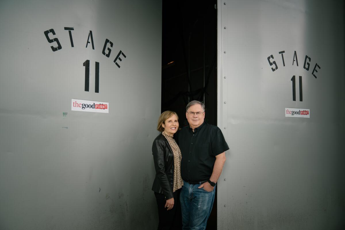 Robert and Michelle King stand in front of doors labeled "Stage 11."