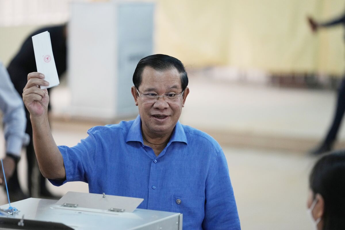 Cambodian Prime Minister Hun Sen, of the Cambodian People's Party (CPP), holds his ballot before dropping it into a ballot box at a polling station in Takhmua in Kandal province, southeast of Phnom Penh, Cambodia, Sunday, June 5, 2022. Cambodians headed to the polls Sunday in local elections that are their first chance to vote since the ruling party of long-serving Prime Minister Hun Sen swept a 2018 general election that was widely criticized as unfair. (AP Photo/Heng Sinith, File)