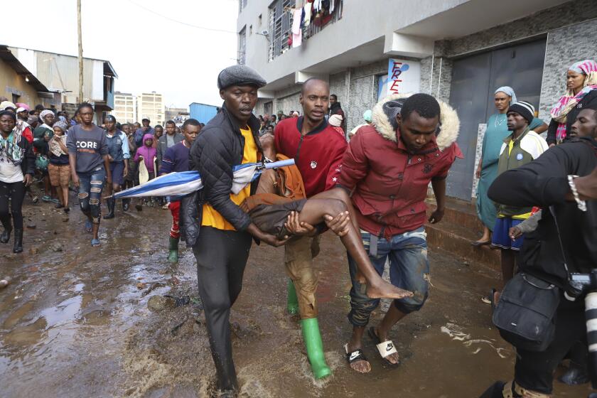 Residents rescue a woman who was caught during heavy rain in the Mathare slum of Nairobi, Kenya, Wednesday, Apr. 24, 2024. Heavy rains pounding different parts of Kenya have led to dozens of deaths and the displacement of tens of thousands of people, according to the U.N., citing the Red Cross. (AP Photo/Andrew Kasuku)