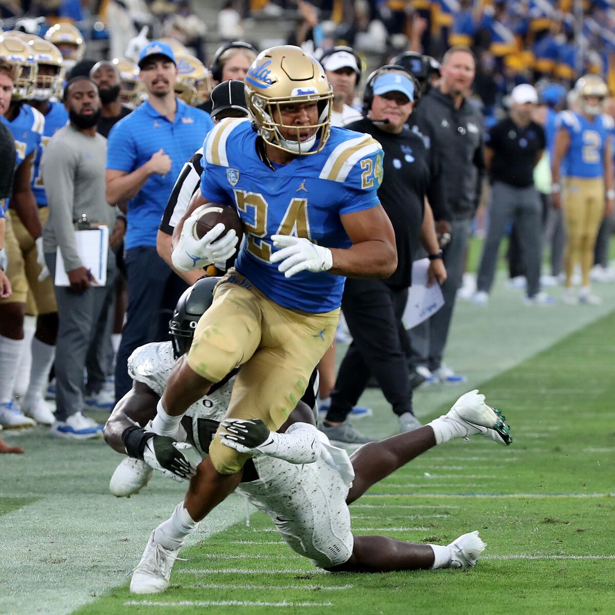 UCLA running back Zach Charbonnet makes a long gain along the sideline.