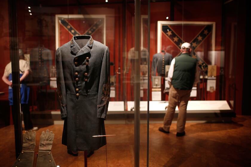 APPOMATTOX, VA - APRIL 08: Tourists view the field coat worn by Confederate General Robert E. Lee when he surrendered to Union forces at the Museum of the Confederacy April 8, 2015 in Appomattox, Virginia. Tomorrow marks the 150th anniversary of Confederate General Robert E. Lee's surrender of the Army of Northern Virginia to Union forces commanded by General Ulysses S. Grant in the McLean House at Appomattox, Virginia. The surrender marked the beginning of the end of the American Civil War in 1865. (Photo by Win McNamee/Getty Images)