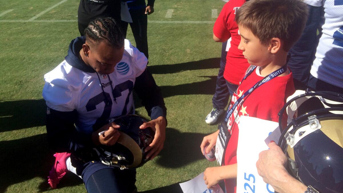 Cornerback Trumaine Johnson signs a helmet for Lucas McCaddon at Rams practice on Saturday.