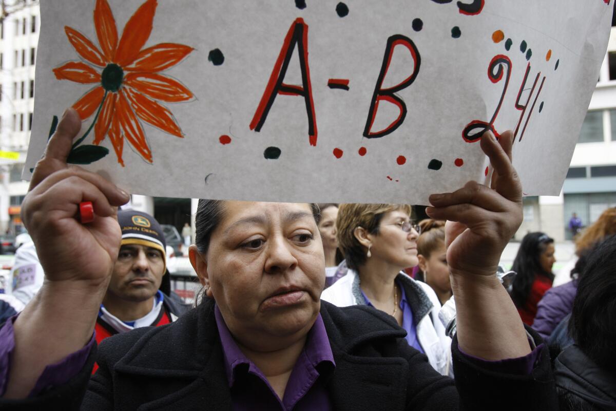 Supporters of AB 241, which would make domestic workers eligible for overtime, rally in Los Angeles in March. The bill passed the Legislature on Thursday.