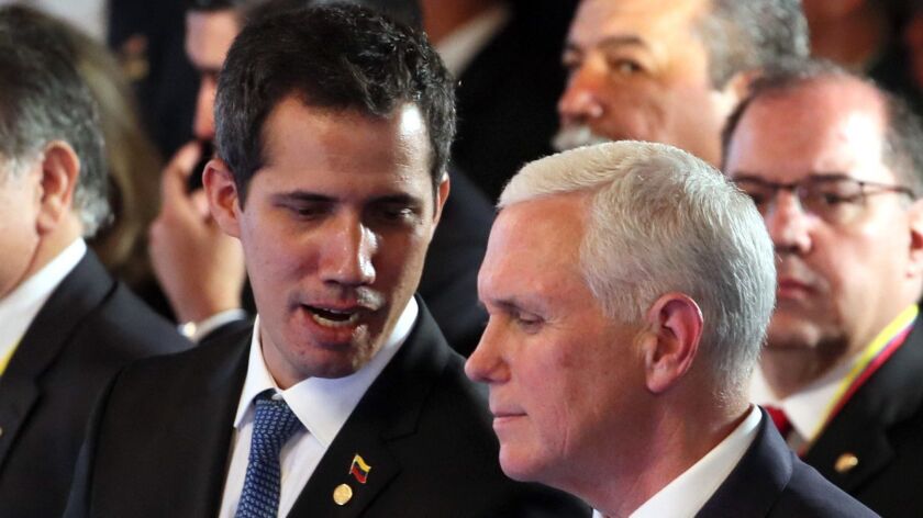 Venezuela's self-proclaimed interim president, Juan Guaido, left, speaks to U.S. Vice President Mike Pence during the opening of the Lima Group Summit, in Bogota, Colombia, on Feb. 25.