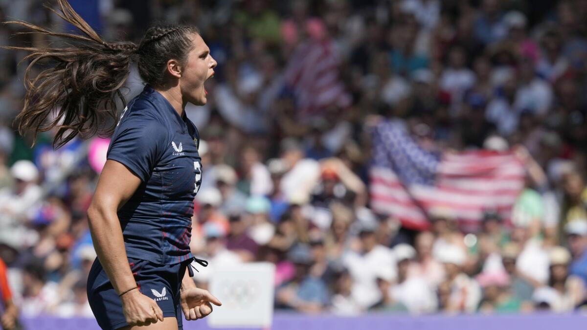 a woman celebrating in front of a packed stadium audience