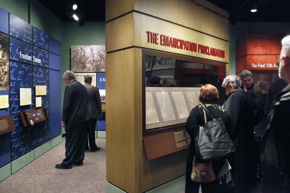 Visitors are seen looking at a display of President Abraham Lincoln's Emancipation Proclamation at the National Archives in Washington.