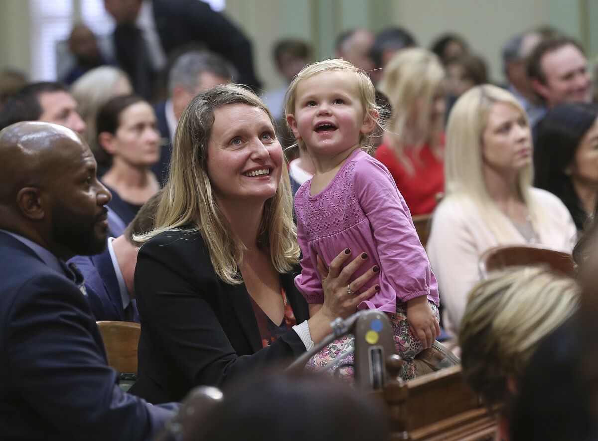 A state Assembly member holds a toddler.
