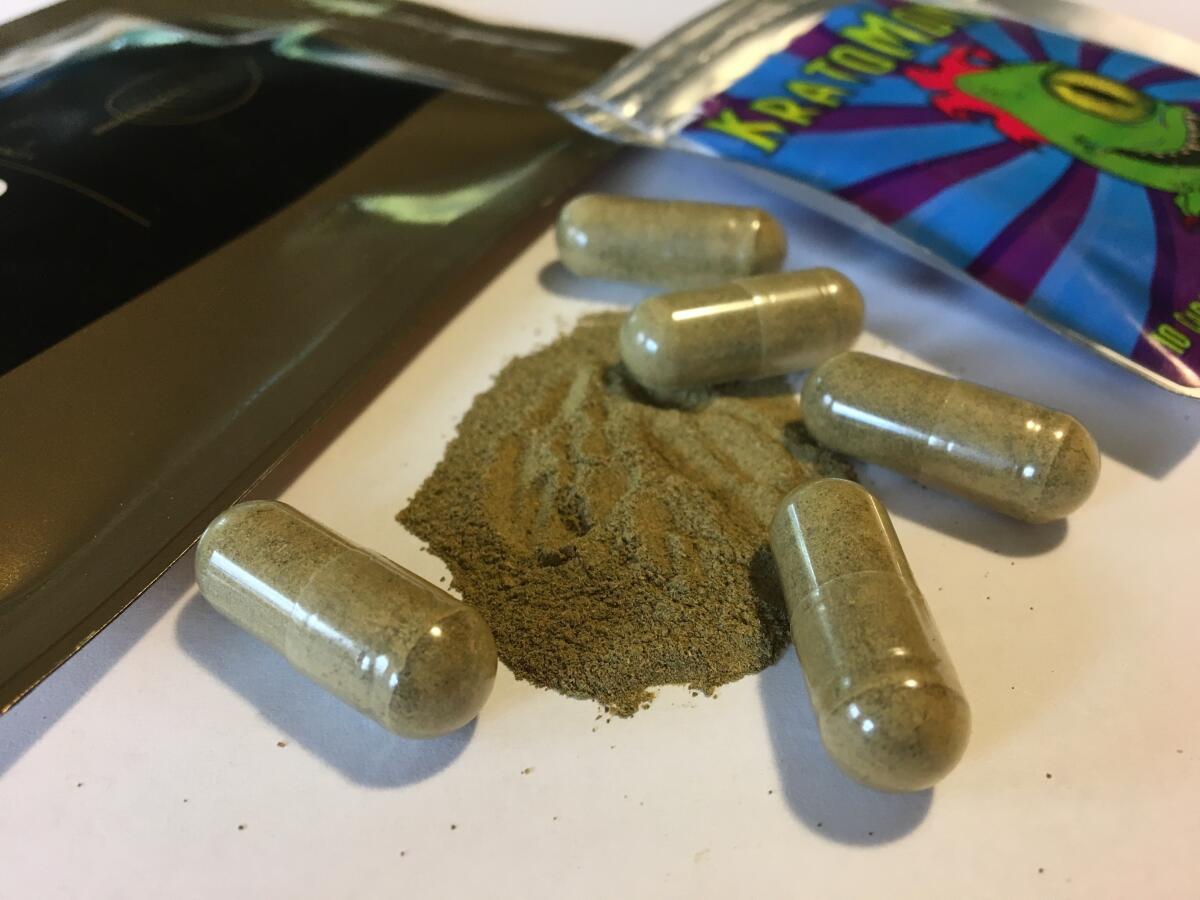 Kratom capsules are displayed on a table.