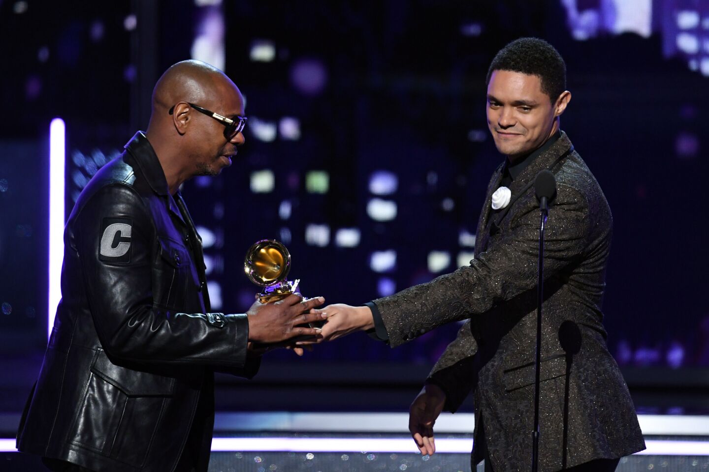 Comedian Dave Chappelle, left, accepts the comedy album Grammy for "The Age of Spin & Deep in the Heart of Texas" from Trevor Noah, right.