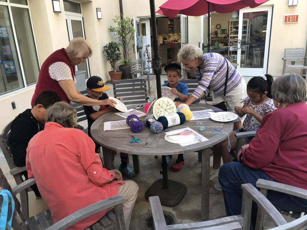 White Sands residents Ann Colaneri, Grace Baldwin, Linda Dotson and Marianne Kocks lead a yarn activity with visiting kids.