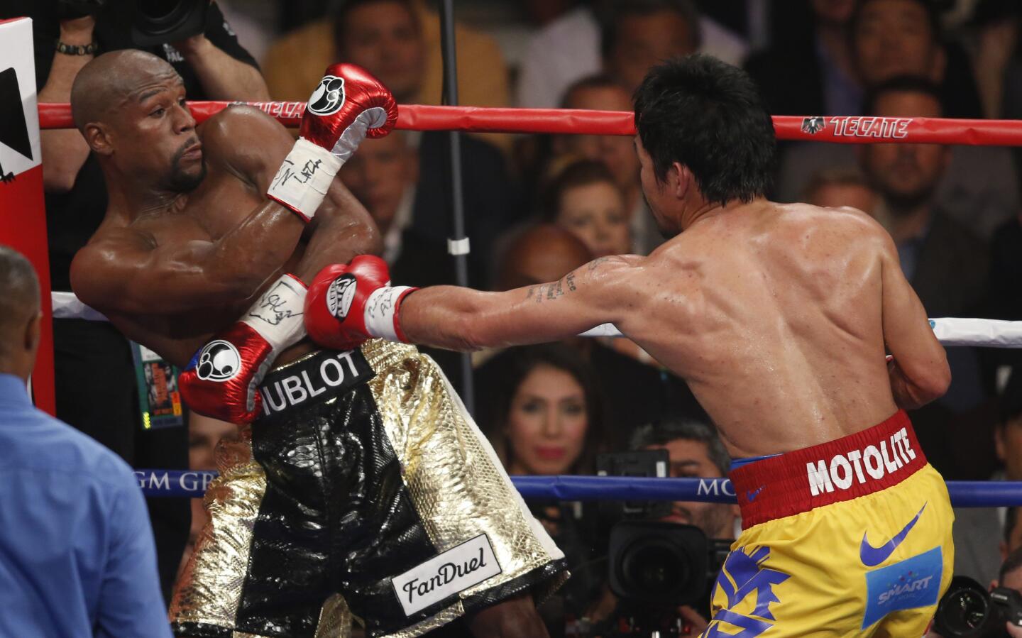 Pacquiao punches Mayweather near the ropes.