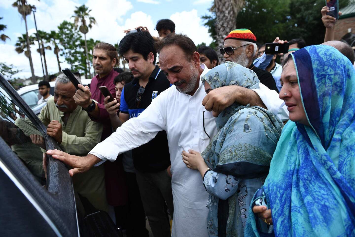 Nasir Shenwari holds his daughter as the casket of Santa Fe High School shooting victim Sabika Sheikh, 17, leaves a funeral in Stafford, Texas, two days after a gunman killed 10 people at the school.