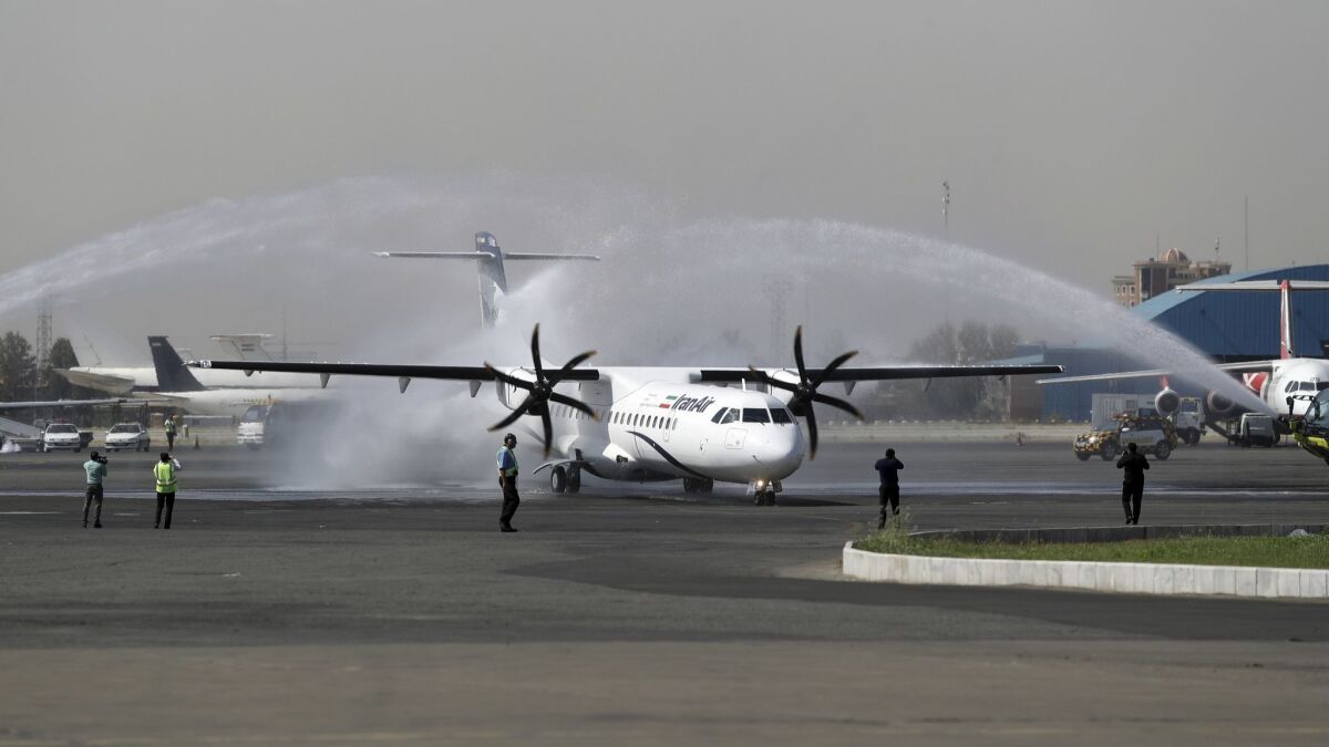 A traditional water cannon salute welcomes a new Iran Air commercial aircraft at Mehrabad airport in Tehran on Aug. 5, 2018. Iran acquired five new ATR72-600 airplanes from a European consortium the day before U.S. sanctions were restored.