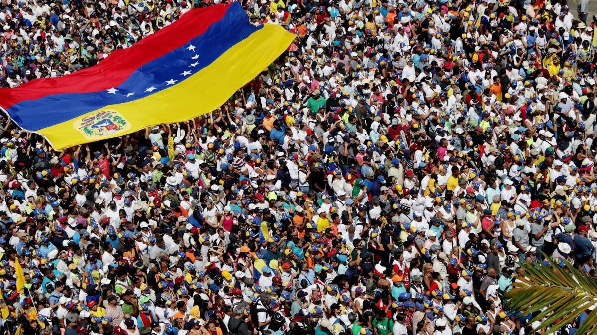 Sympathizers of the opposition wave a giant Venezuelan flag during a march Saturday against Nicolas Maduro's government, in Caracas, Venezuela, Feb. 2, 2019.