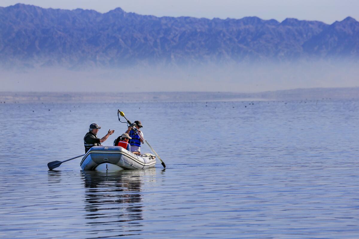 Two people in a rubber raft on a lake