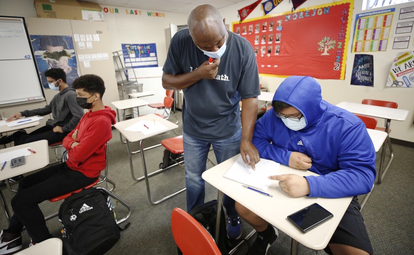 Hawthorne high school math teacher Cordell Haynes, center, works with 11th-grader Justin Ake.