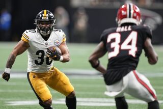 El running back Jaylen Warren (30) corre por los Steelers de Pittsburgh ante el cornerback Darren Hall (34), de los Falcons de Atlanta, en duelo del domingo 4 de diciembre de 2022, en Atlanta. (AP Foto/Brynn Anderson)