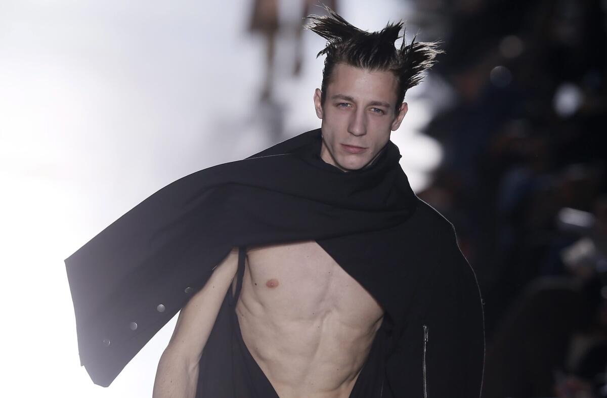 A model wears a toga-like garment on Rick Owens' runway. (No, we can't show you the peepholes.)