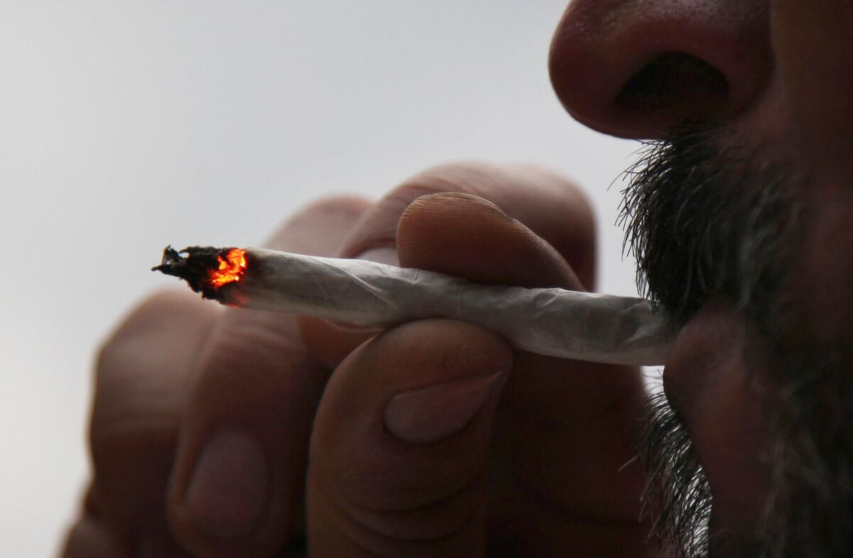 A man smokes a marijuana cigarette at his home in Mexico City. 
