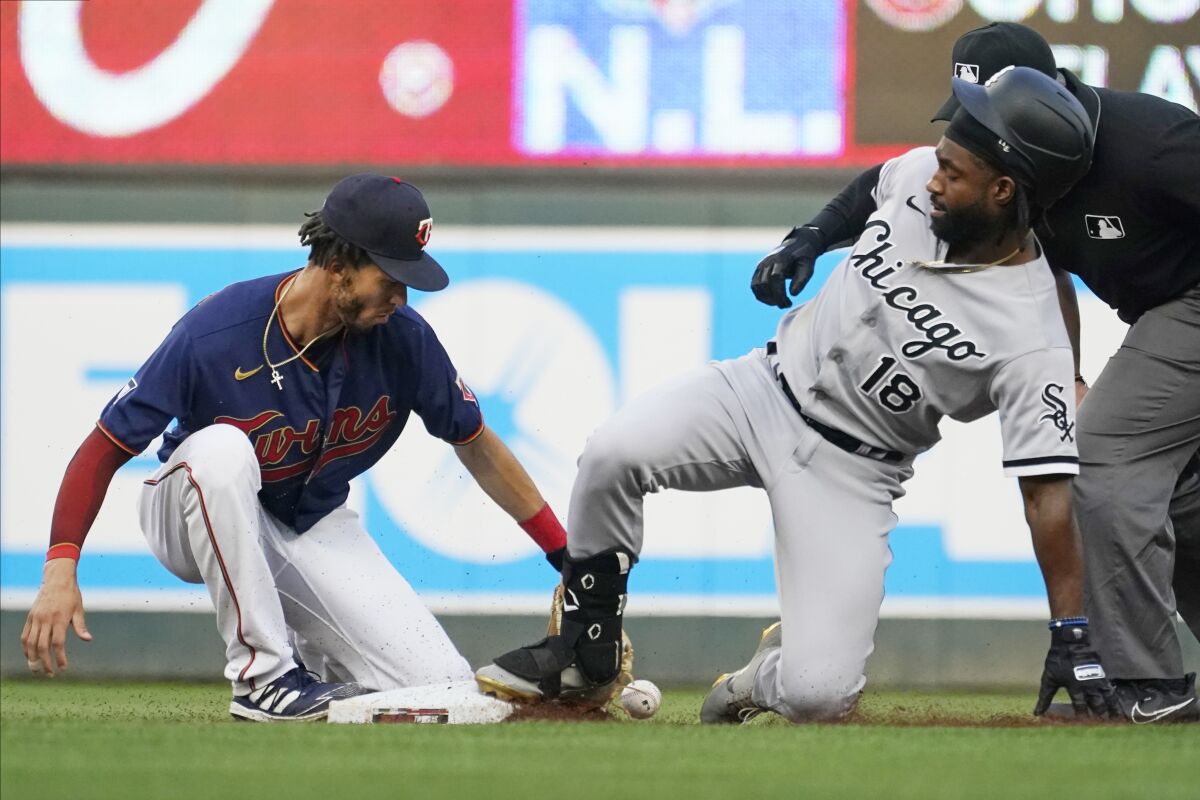Minnesota Twins shortstop Andrelton Simmons can't get to the ball as Chicago White Sox's Brian Goodwin doubles in the first inning of a baseball game, Monday, Aug. 9, 2021, in Minneapolis. (AP Photo/Jim Mone)