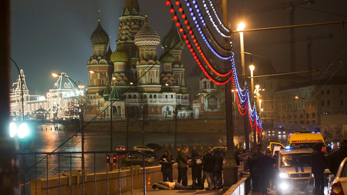 In this Feb. 28, 2015, file photo Russian police investigate the death of Boris Nemtsov, who was shot as he walked with a companion just off Red Square, with St. Basil Cathedral in the background, in Moscow.