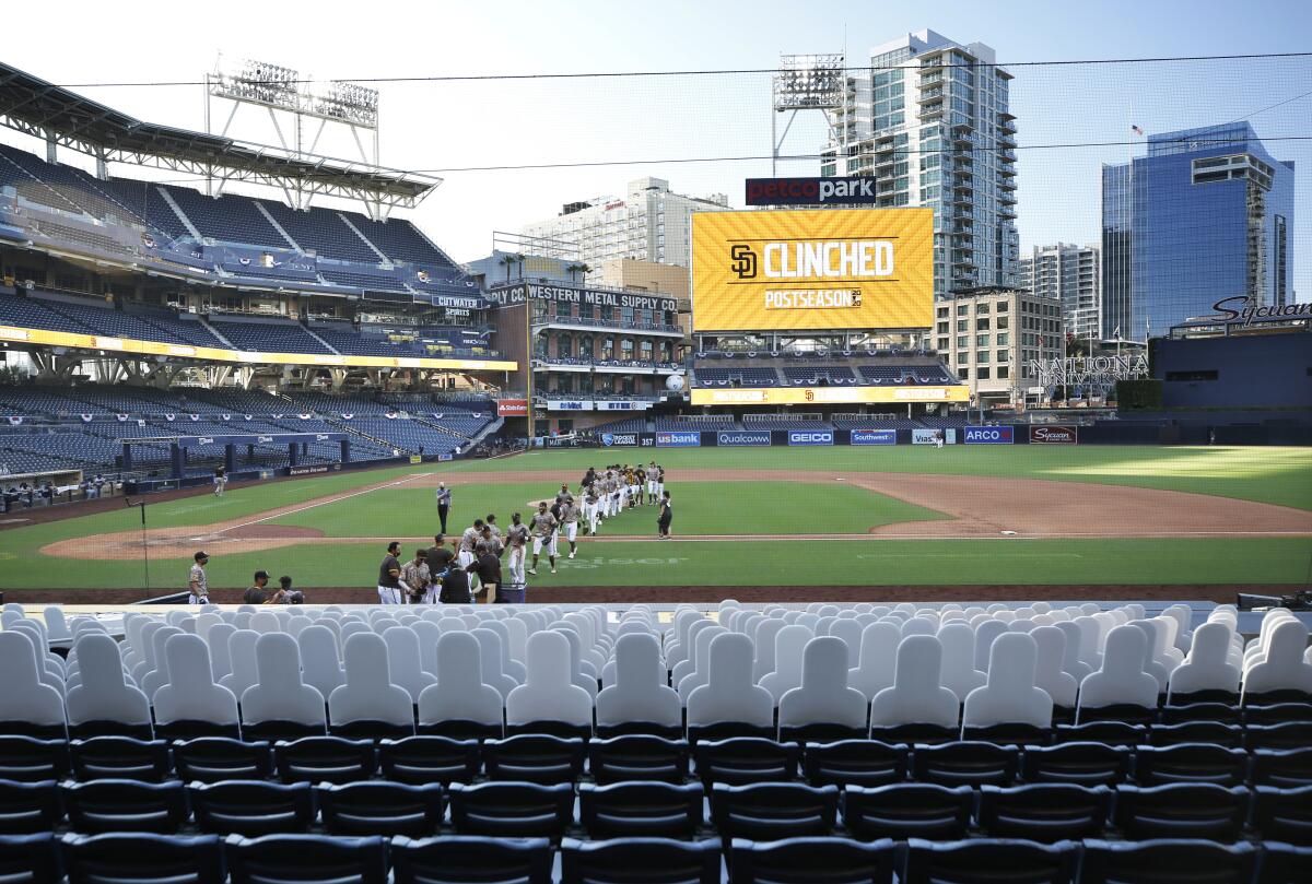 Padres celebrate clinching postseason berth in 2020 in front of cardboard cutouts at Petco Park. 