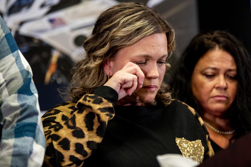 RIVERSIDE, CA - NOVEMBER 30, 2022: Michelle Blandin wipes her tears while talking about her slain sister and parents at the home where she grew up at a press conference at the Riverside Police Department's Magnolia Station on November 30, 2022 in Riverside, California. The victims were identified as Mark Winek, 69; his wife, Sharie Winek, 65; and their daughter Brooke Winek, 38, who lived in the house with Brooke's two teenage daughters. The 15-year-old teen was involved in an online relationship with a predator who is accused of the murders. Police say Austin Lee Edwards, 28, of North Chesterfield, Va., killed the three before leaving with the teen in his vehicle. He was later killed in a shoot-out with police in San Bernardino County.The teen is safe.(Gina Ferazzi / Los Angeles Times)