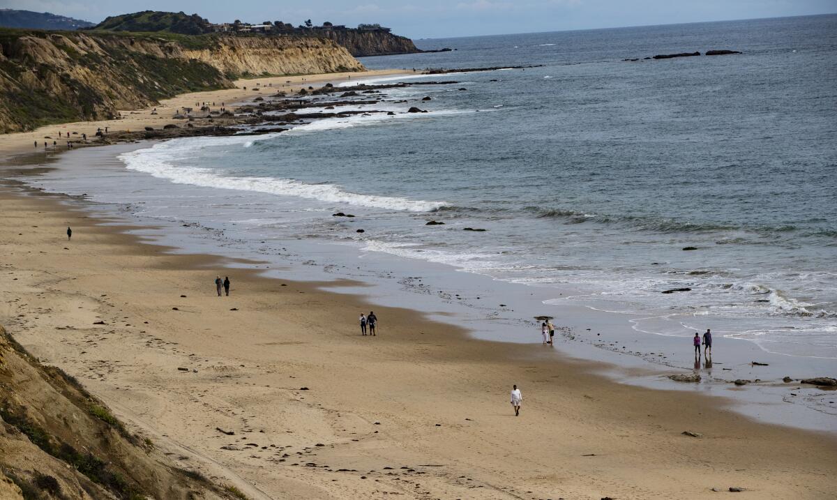 People walk along the shoreline 