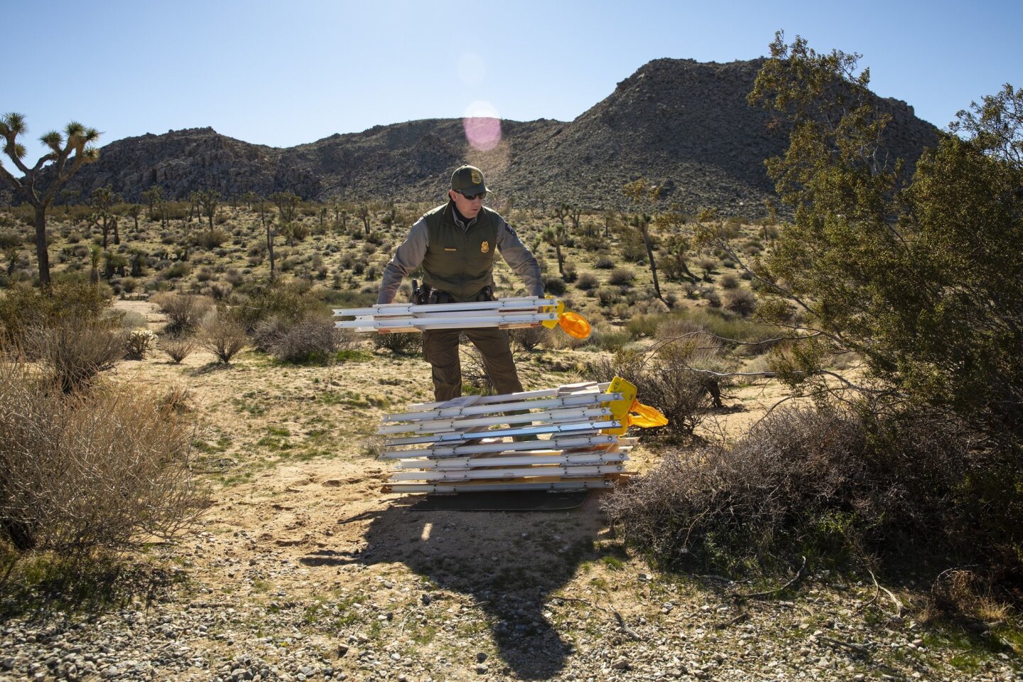 Ranger Rob Evans places temporary barriers off the side of the road near Joshua Tree National Park. The Park will close to all visitors because of damage to the park during the partial government shutdown.