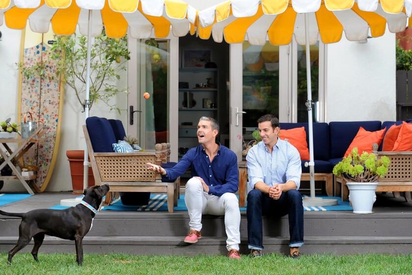 Gray Malin, left, and husband Jeff Richardson relax on the deck of their West Hollywood home with their with dog, Stella. Inspired by Malin's photography, they added Pagoda parasols from California Umbrella for a Mediterranean beach feeling.
