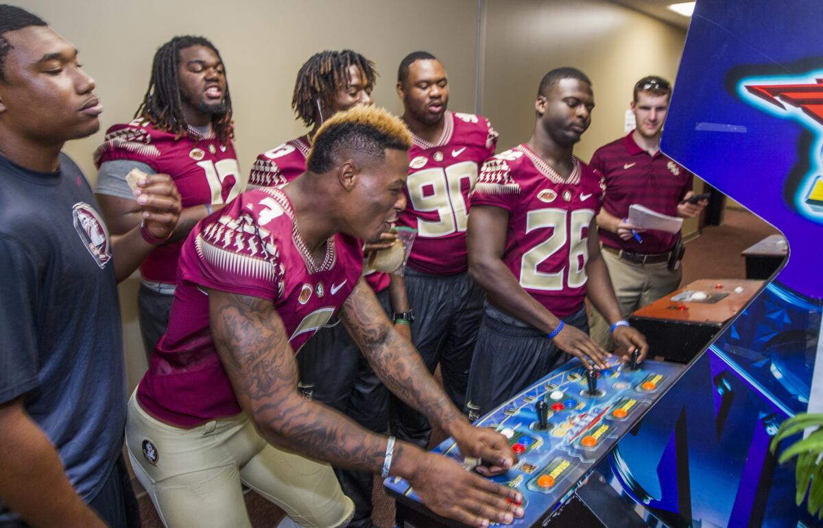 Derwin James Jr., left, plays video games with other Florida State players during the team's media day in 2015.