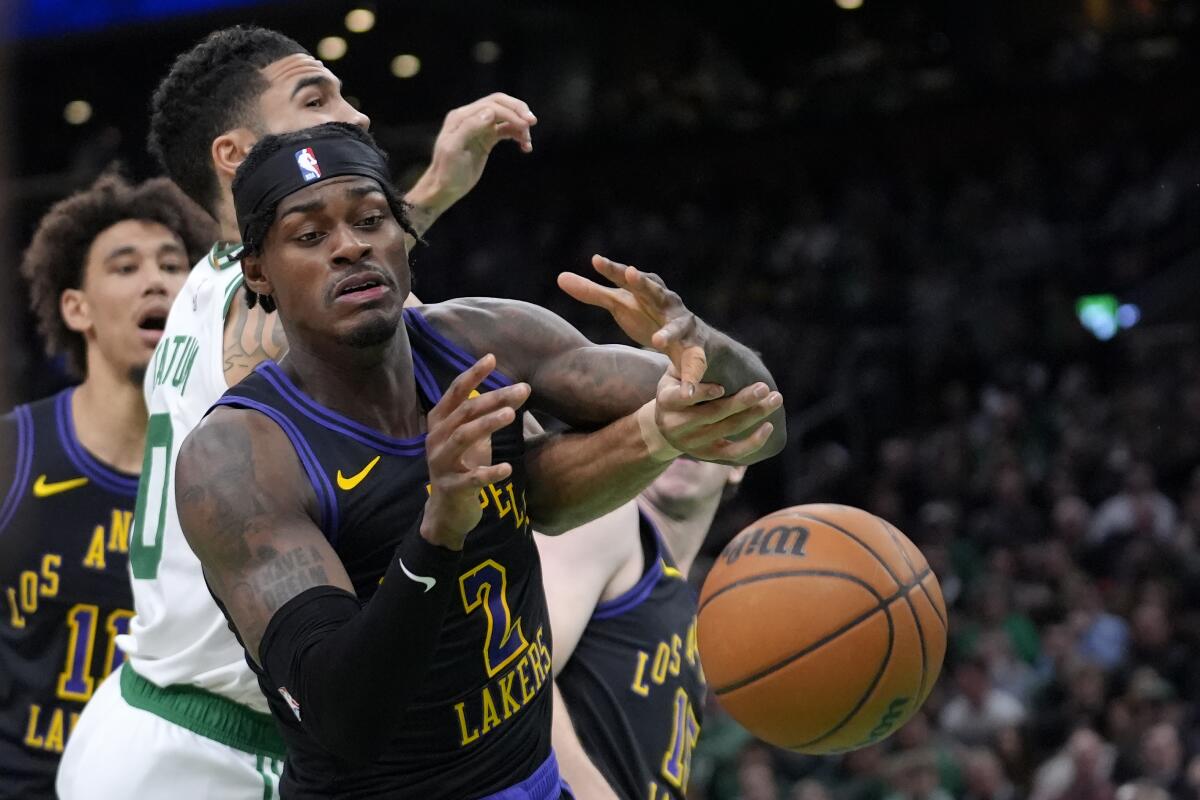 Lakers forward Jarred Vanderbilt, foreground, tries to grab a loose ball in front of  Celtics forward Jayson Tatum,
