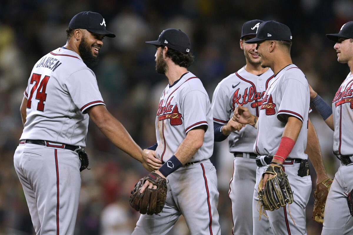 Atlanta Braves, including closer Kenley Jansen, left, celebrate a win in a baseball game against the Seattle Mariners, Friday, Sept. 9, 2022, in Seattle. The Braves won 6-4. (AP Photo/Caean Couto)