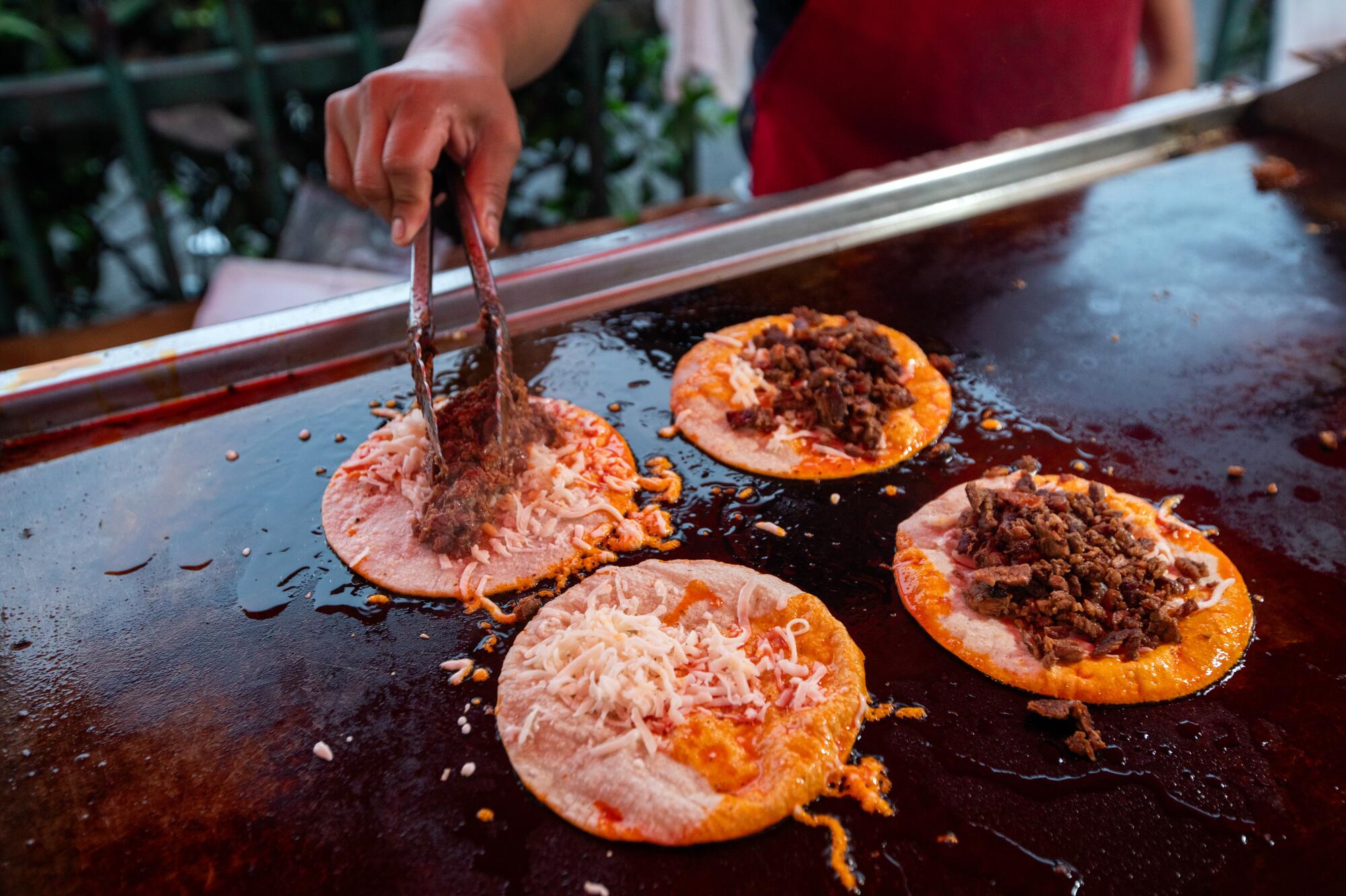 A South L.A. food vendor prepares tacos.