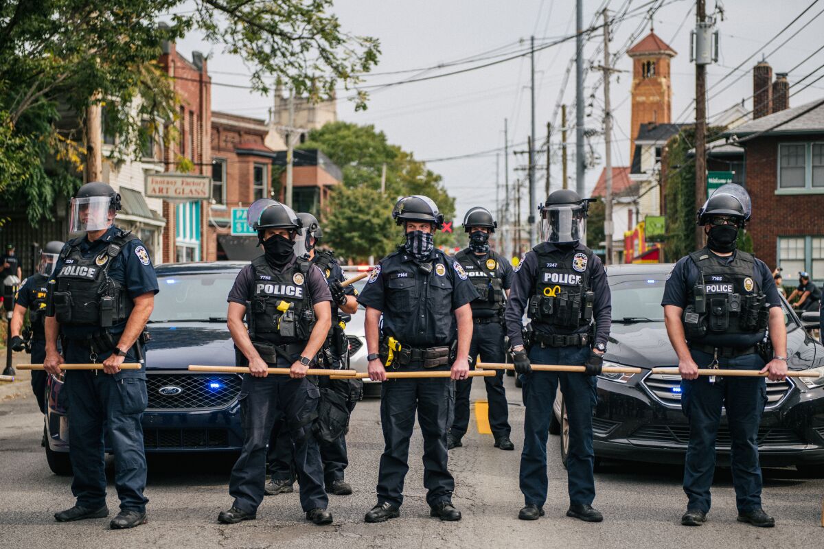 Police officers form a line during protests in Louisville, Ky.