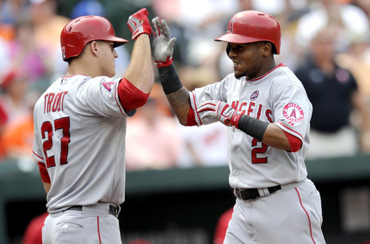 Angels shortstop Erick Aybar (2) gets a high-five from teammate Mike Trout after delivering a bases-loaded triple and then scoring on an error by Orioles in a game last season in Baltimore.