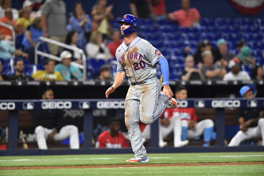 Pete Alonso, de los Mets de Nueva York, se dispone a anotar en un doble del dominicano Starling Marte ante los Marlins de Miami, el sábado 1 de bril de 2023 (AP Foto/Michael Laughlin)