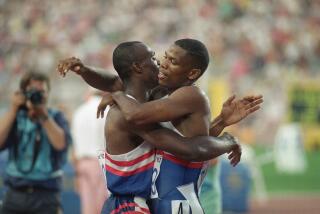 USA teammates Quincy Watts of Detroit, Mich., right and Steve Lewis of Fremont, Calif. hug.