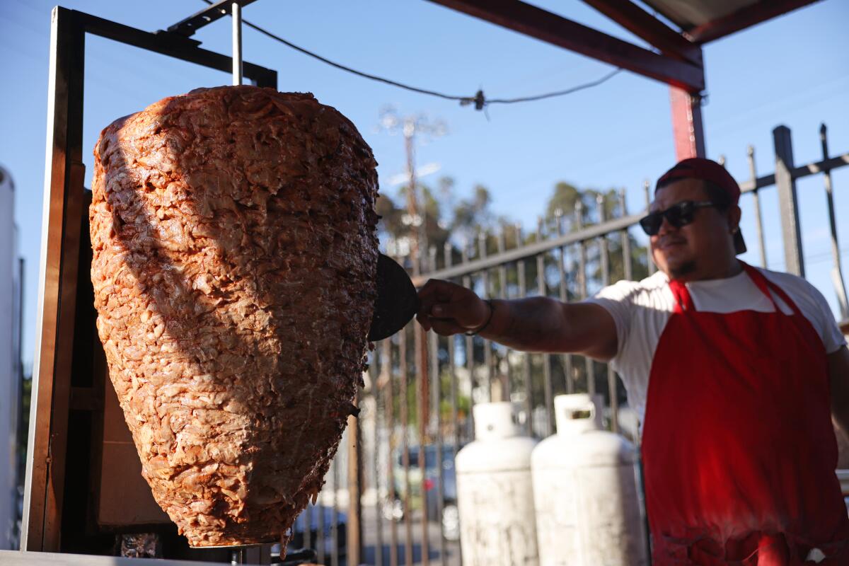 Jesus Koyot tends to a dome of pork on a vertical spit at Avenue 26 Tacos in Little Tokyo. 
