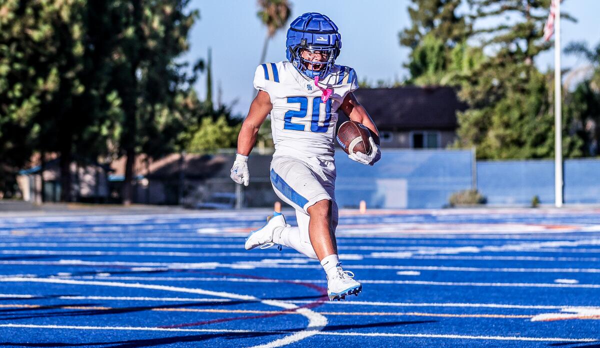 Elijah Robinson runs on the field with the ball.