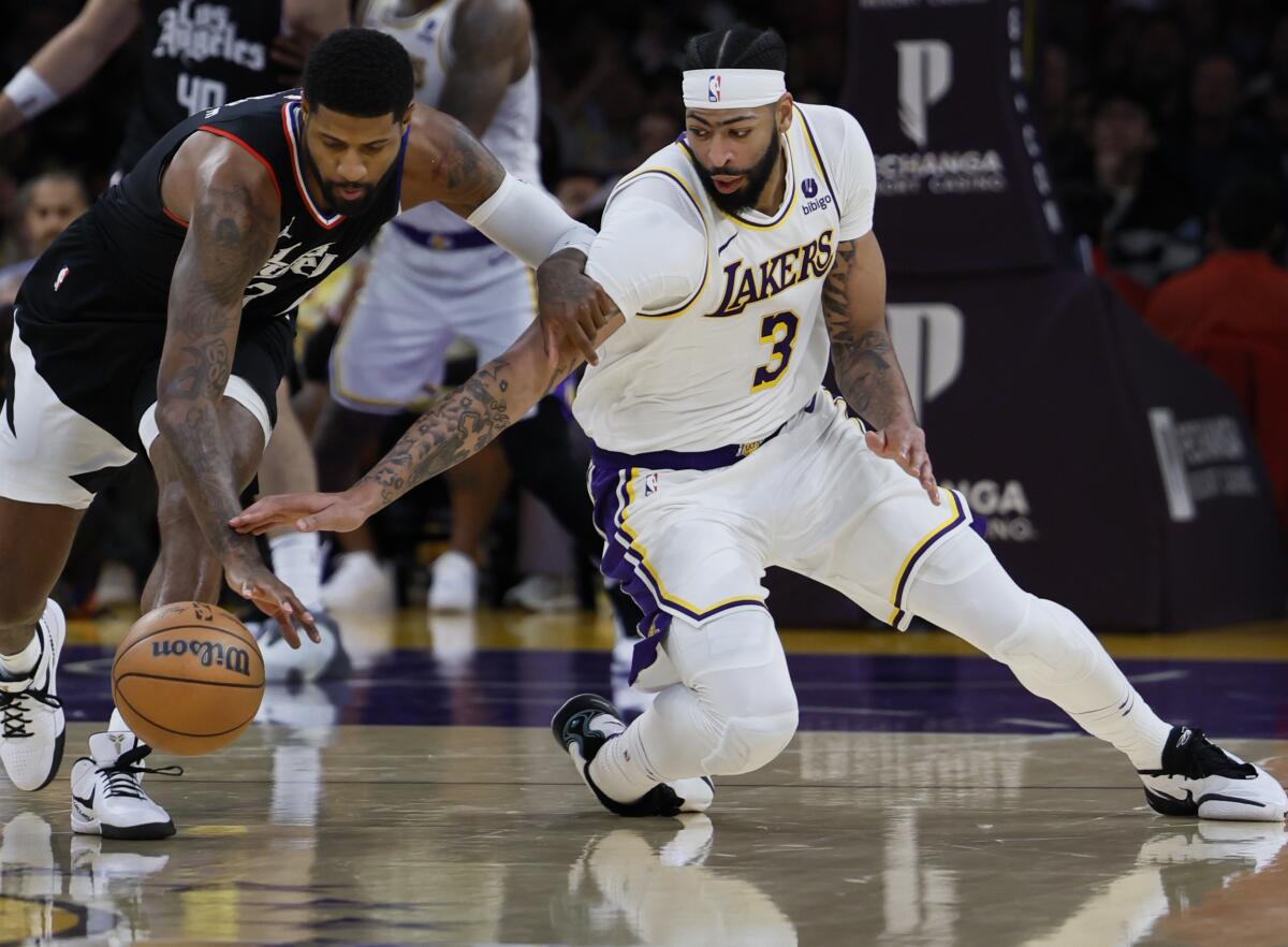 Lakers' Anthony Davis, right, battles the Clippers' Paul George for a loose ball during Sunday's game at Crypto.com Arena.