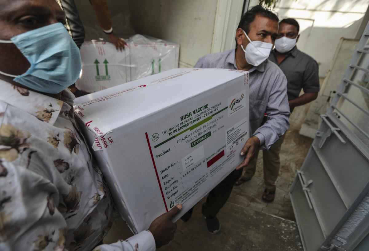 People wearing masks carry a large white cardboard box with a label that reads "rush vaccine"