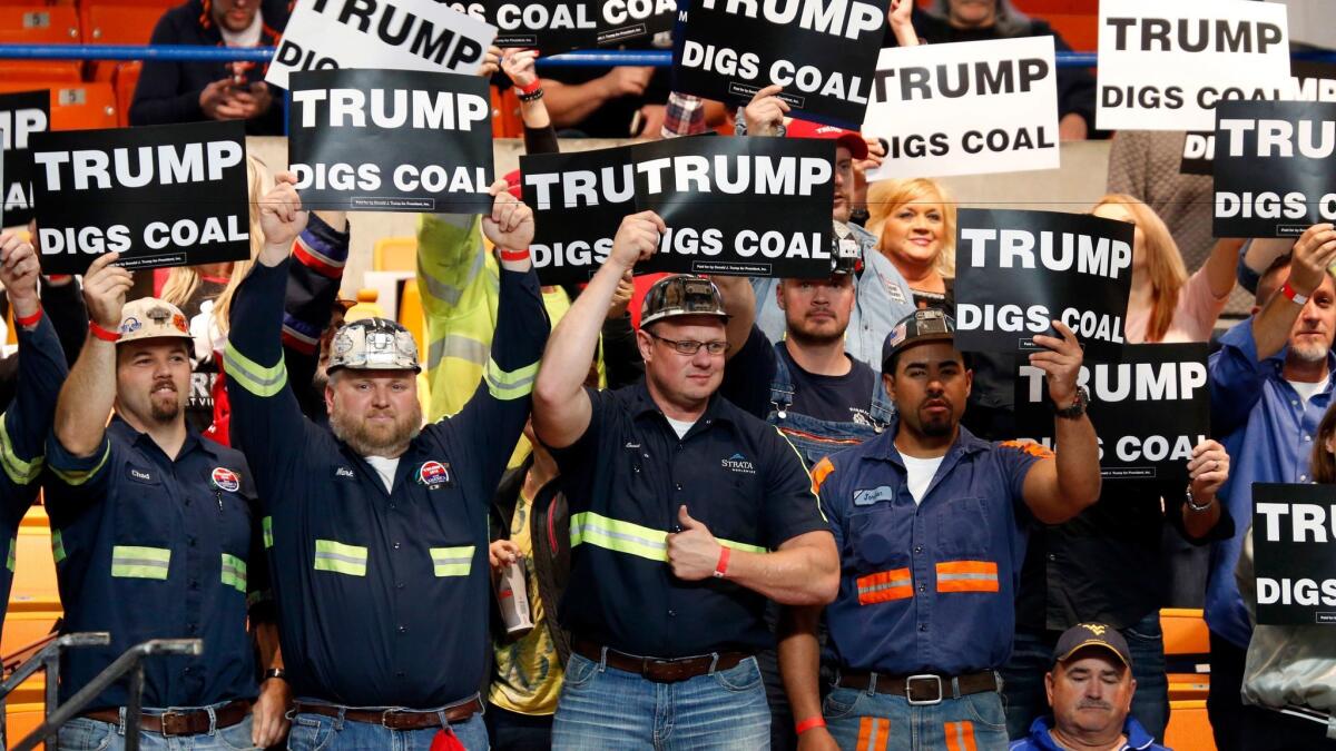 A group of coal miners wave signs for Republican presidential candidate Donald Trump as they wait for a rally in Charleston, W.Va. to begin on Thursday, May 5.